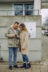 Zwei Personen stehen in Oberreut vor dem Schild zum Quartiersspaziergang 2.0 und schauen in ein Mobiltelefon.