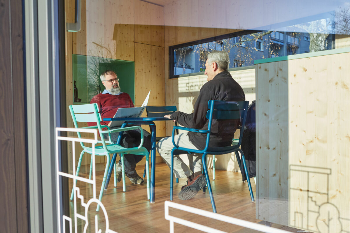 Ein Mieter ist im Servicebüro bei einem Beratungsgespräch mit einem Kundenbetreuer.