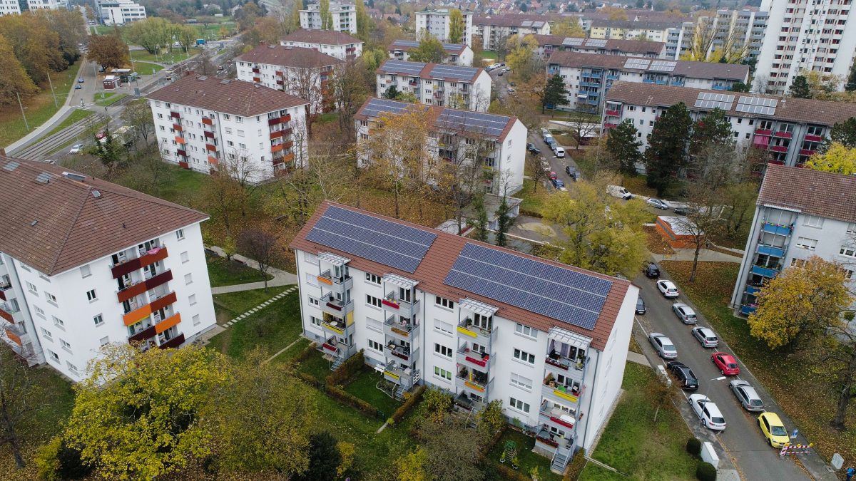 Luftbild auf ein Gebäude der Volkswohnung mit PV-Anlagen auf dem Dach.