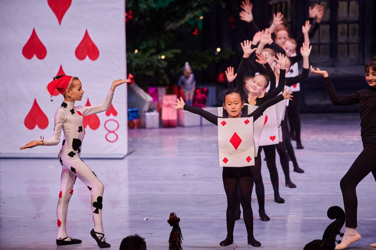 Kinder in Kostümen stehen auf einer Bühne und führen etwas auf.