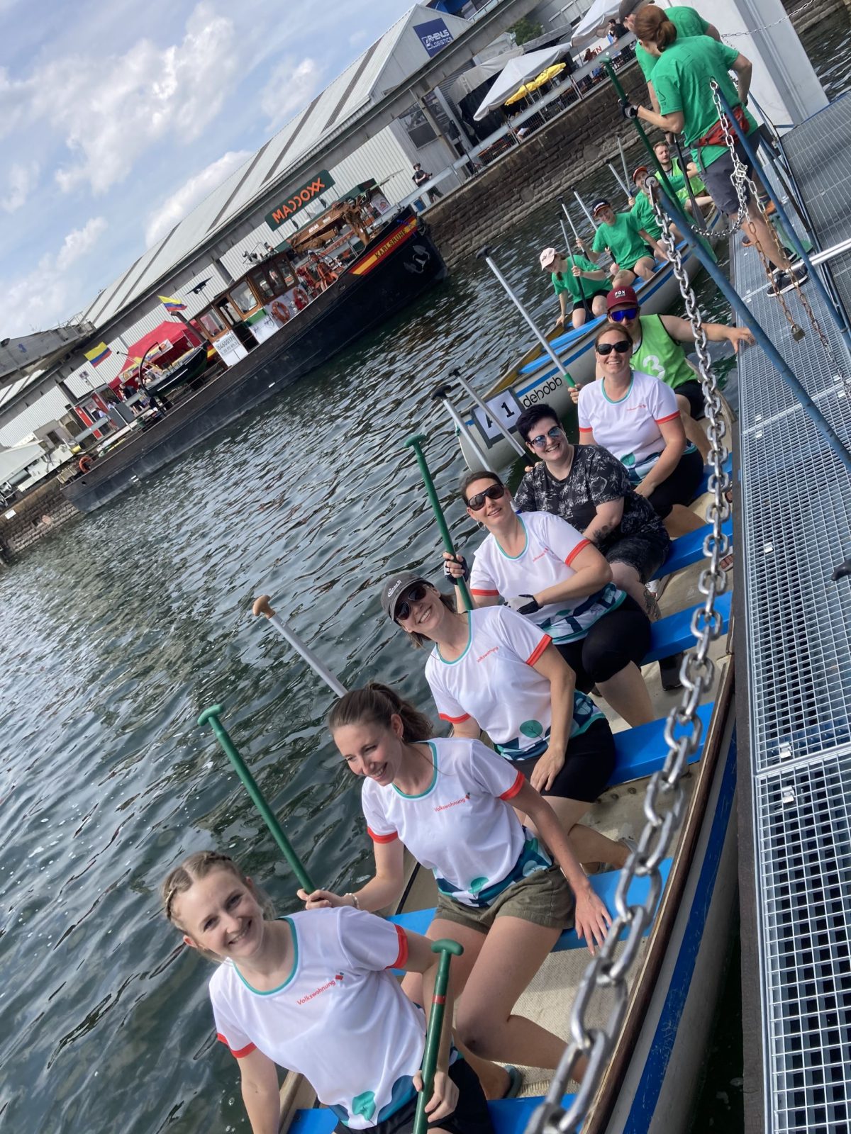 Mitarbeitende der Volkswohnung sitzen in einem Ruderboot.