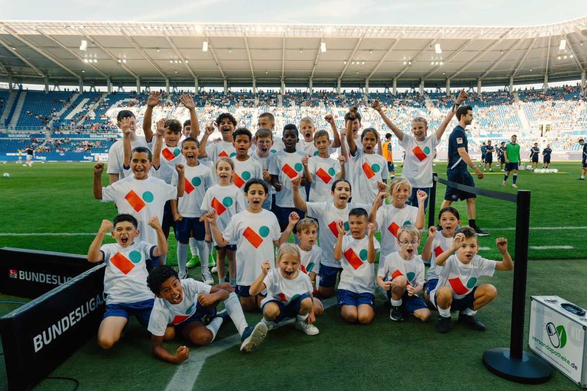 Gruppenfoto von Kindern unserer Mieterschaft auf dem Rasen im KSC-Stadion.