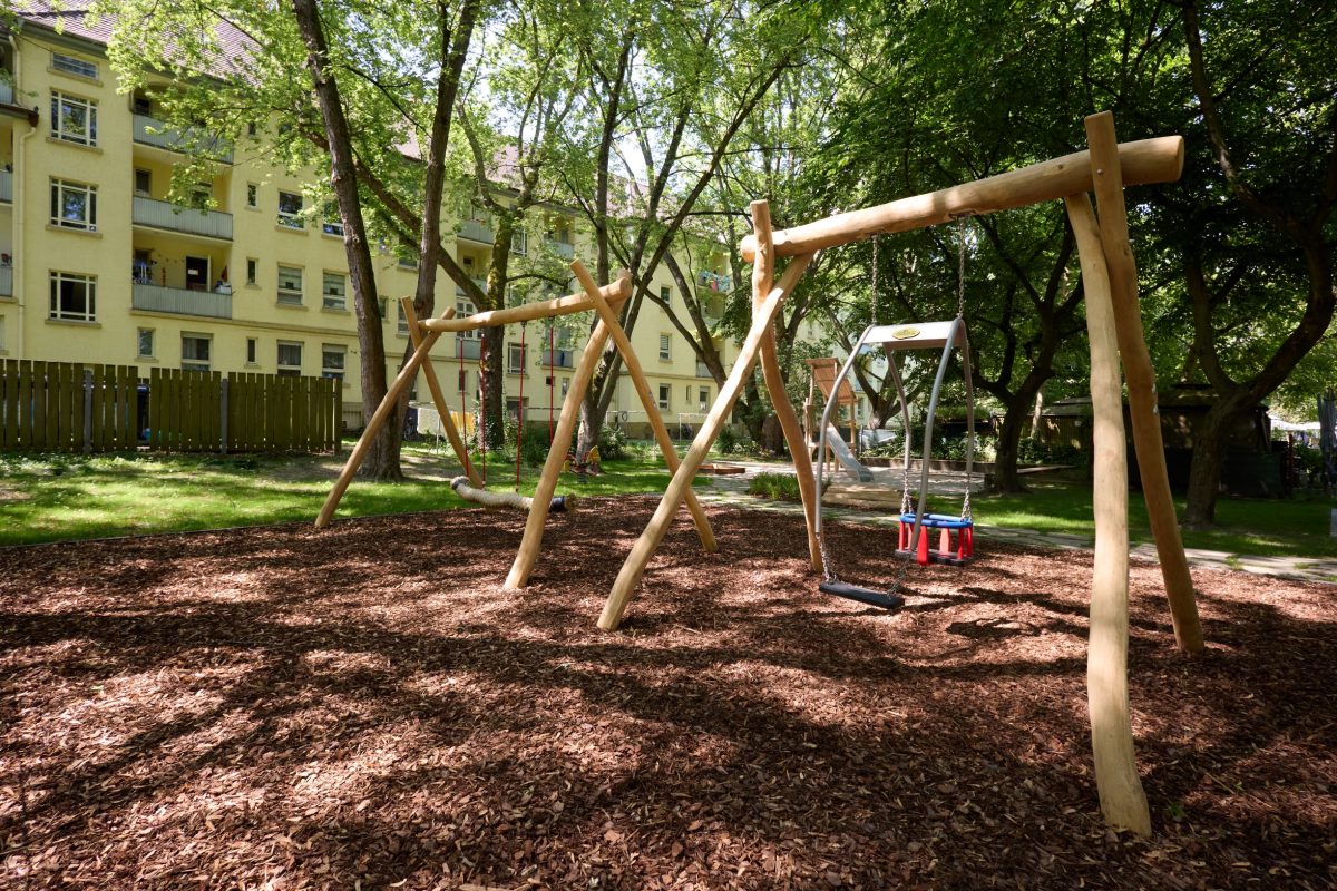 Neue Schaukeln und Spielgeräte auf einem Spielplatz mitten im Grünen.