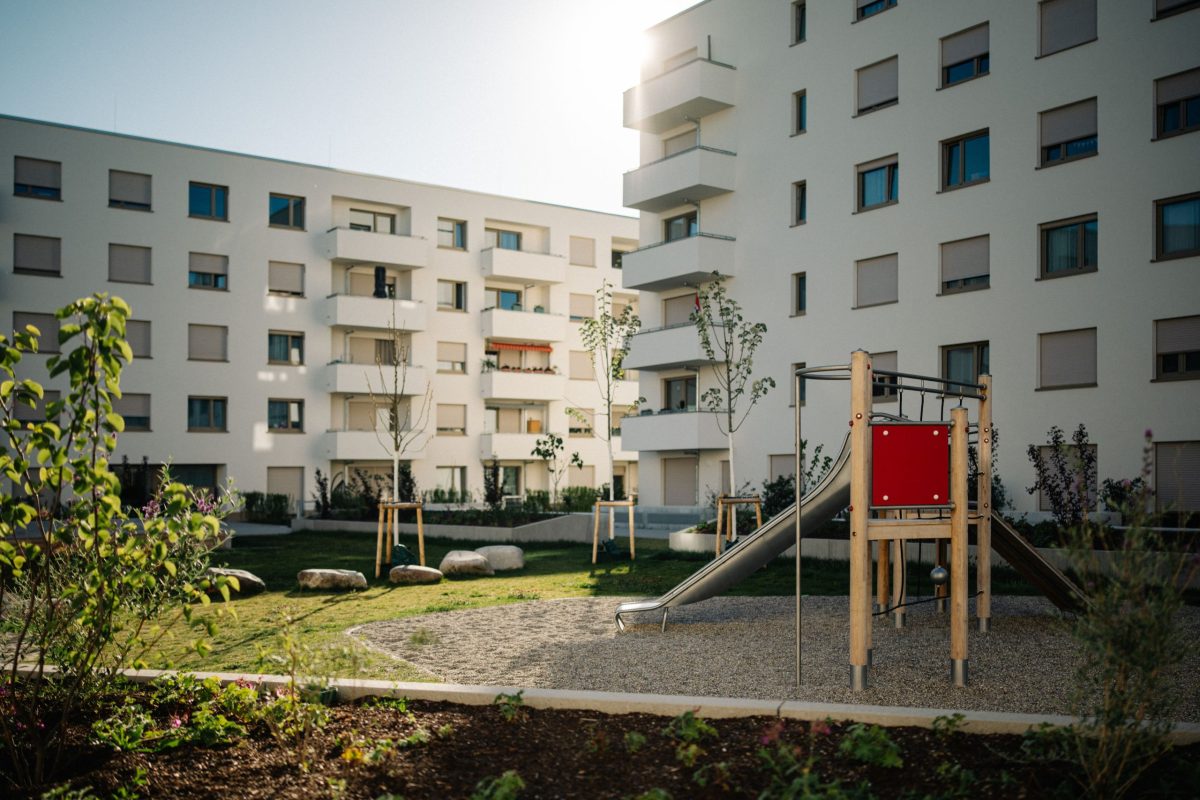 Blick auf den begrünten Innenhof mit Spielgeräten in der Woerishofferstraße in Karlsruhe Oberreut.