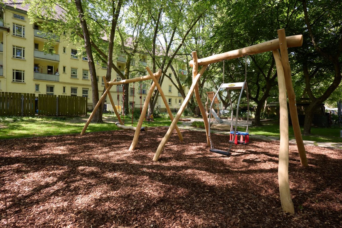 In einem großzügigen Innenhof gibt es einen Spielplatz mit Schaukeln und Rutschen.