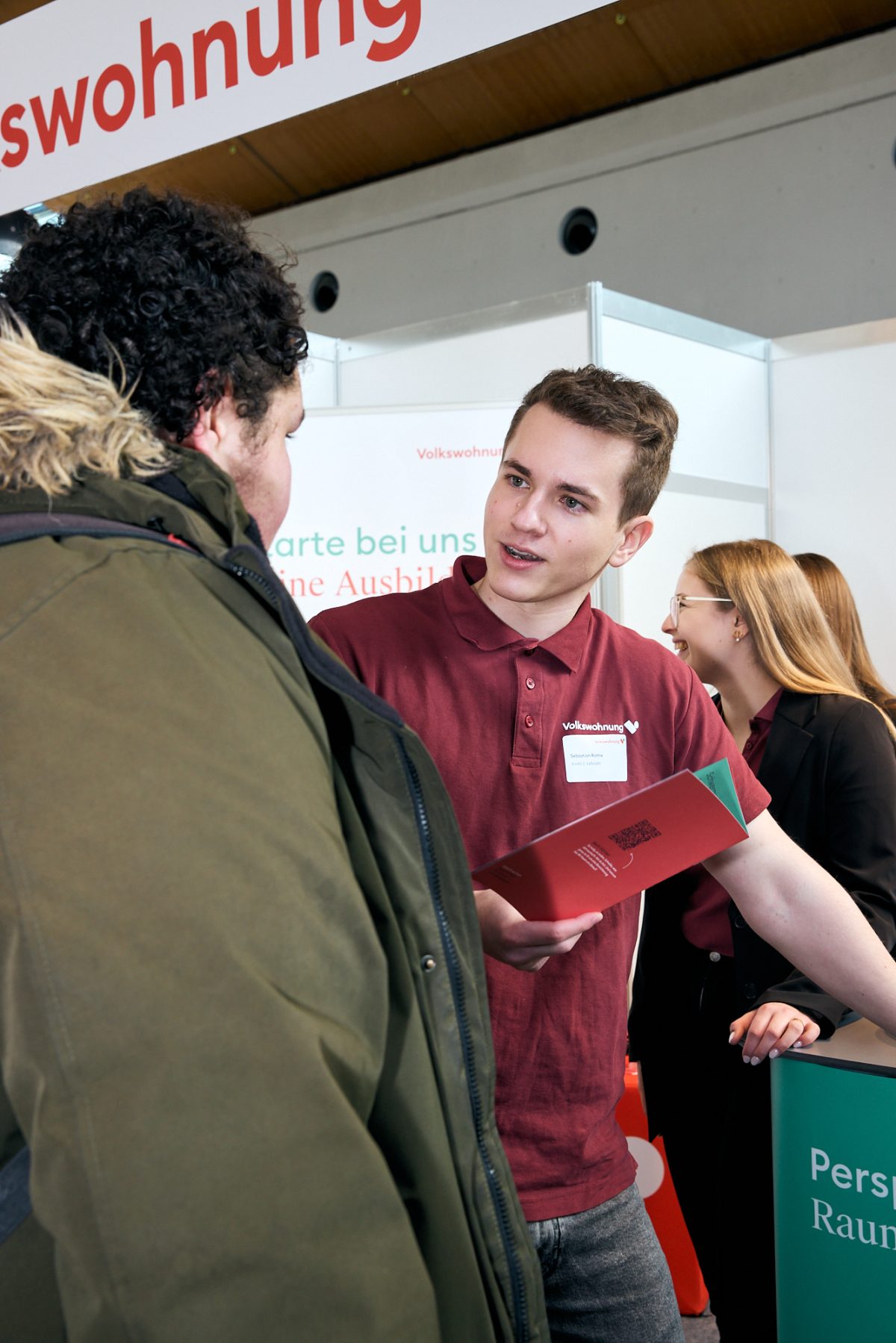 Auszubildende der Volkswohnung informieren Besucherinnen und Besucher an einem Messestand über Ausbildungsangebote.